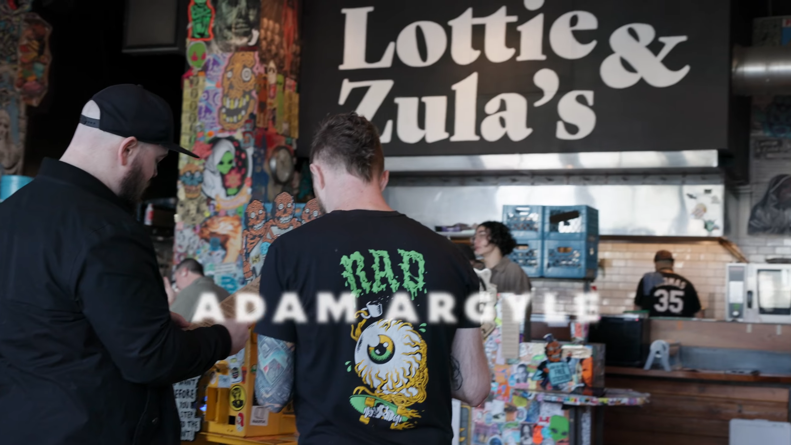 Jason and Adam looking at a food menu in a punky lunch location.